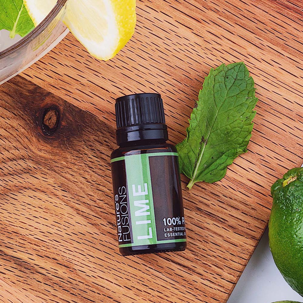 lime essential oil with mint leaves and wood