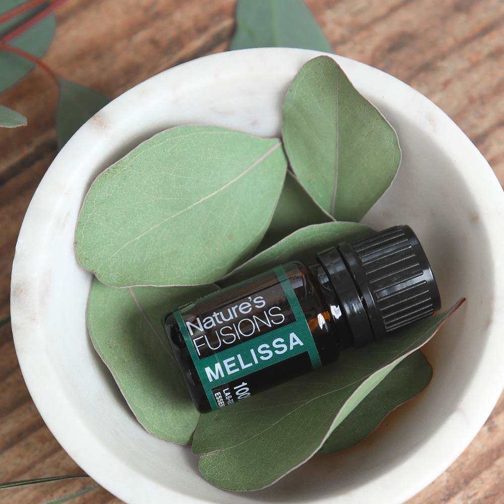 Nature's Fusions melissa essential oil in bowl with leaves