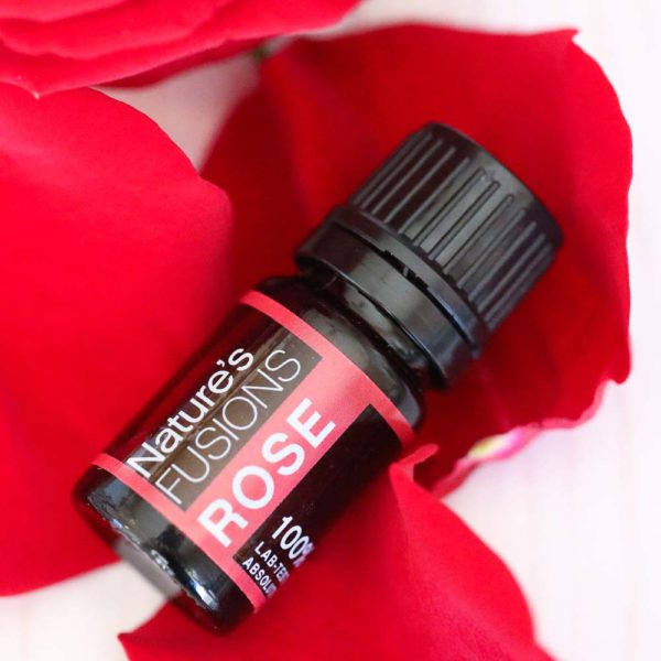 rose essential oil bottle on petals