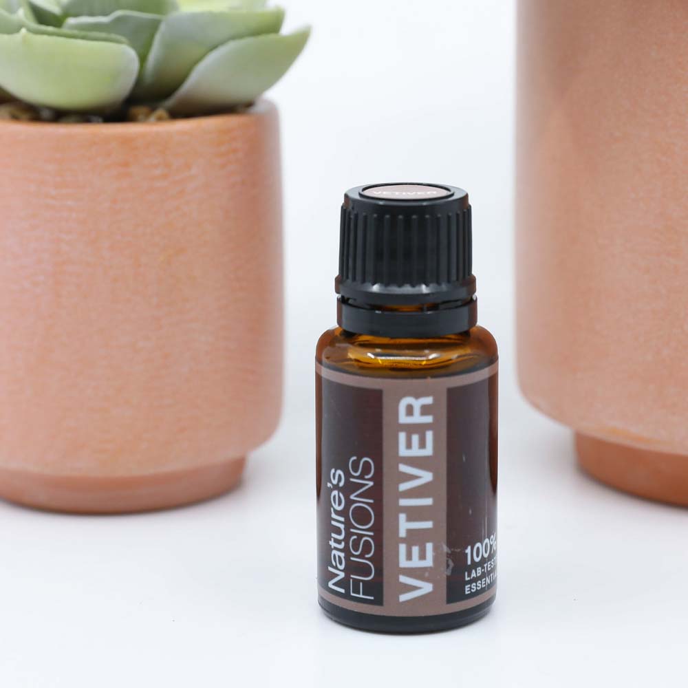 vetiver oil bottle with clay potted plants
