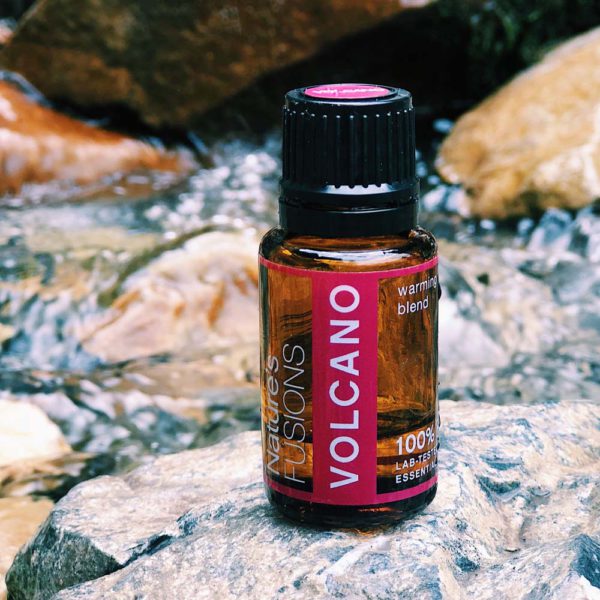 Volcano essential oil bottle on rock in river