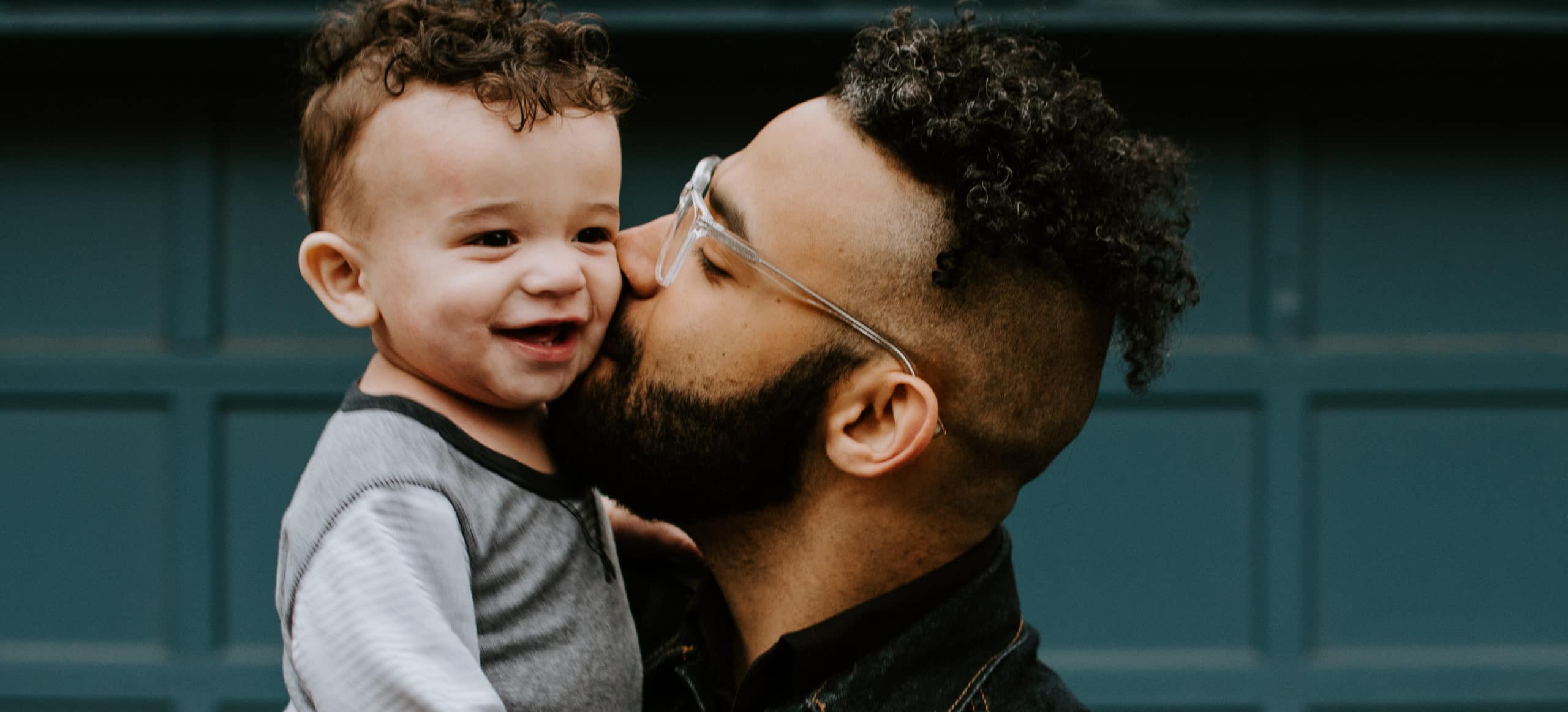 father kissing toddler