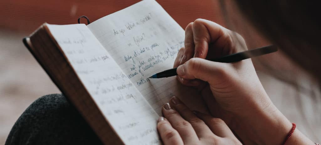 person writing in notebook