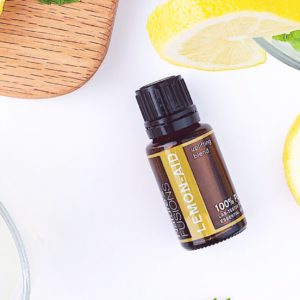 bottle of Lemon-Aid on a counter with sliced lemon