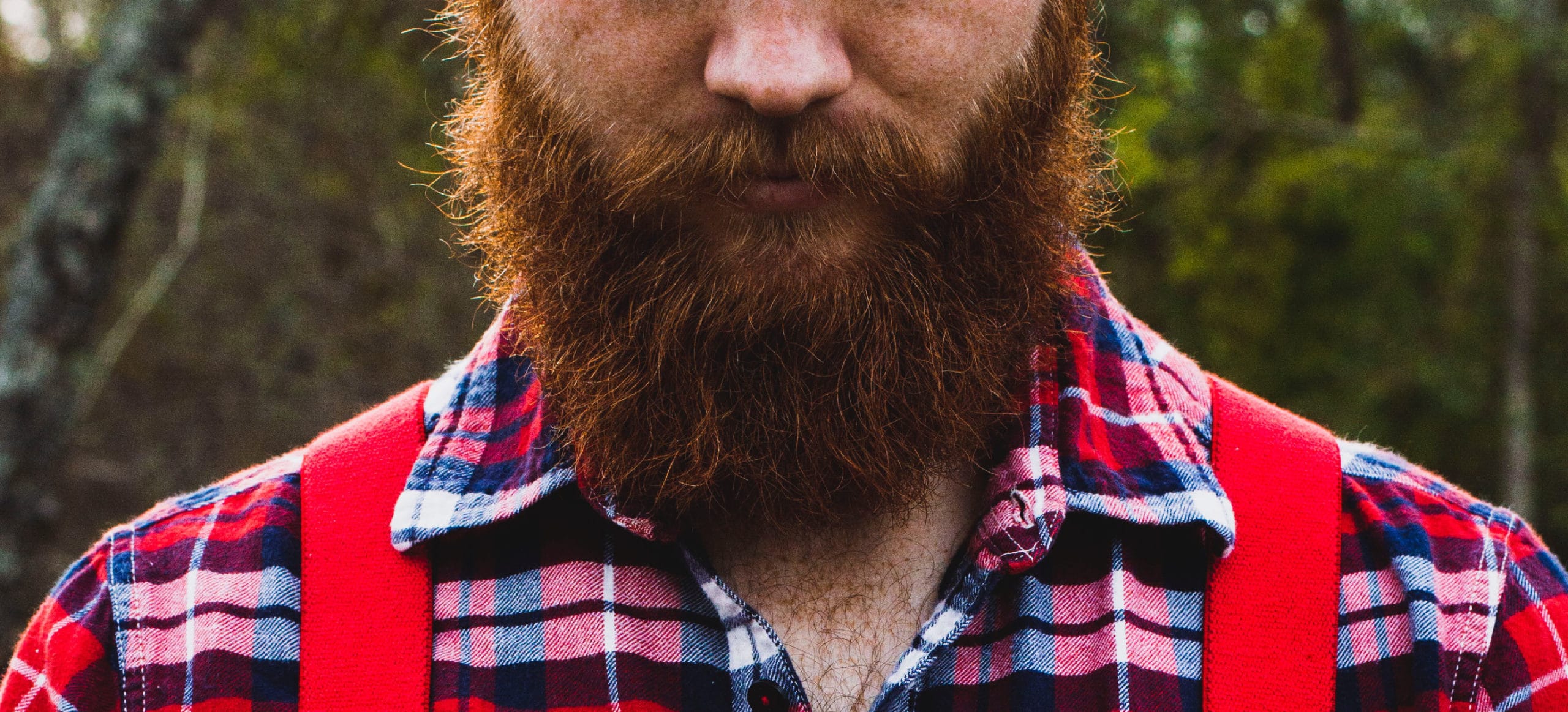 beard shot of man wearing red plaid and overalls