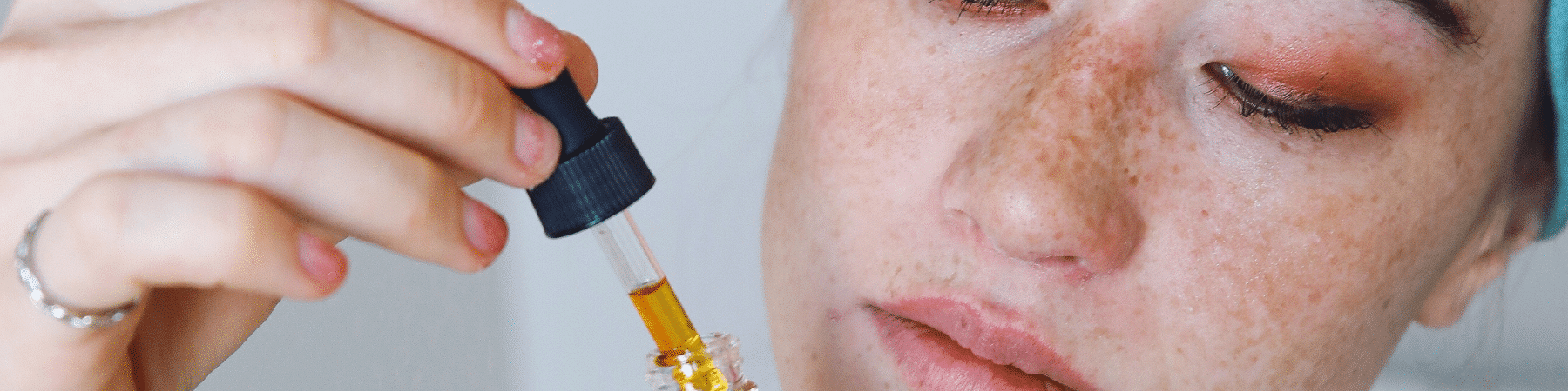 close up of woman applying facial oil