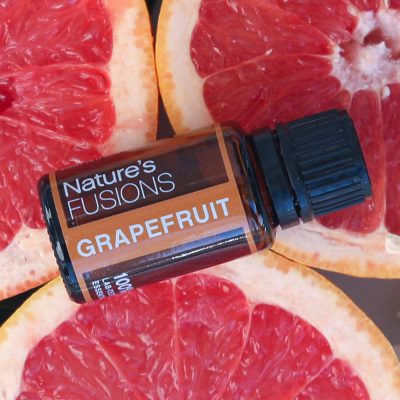 grapefruit essential oil 15 ml bottle on slices