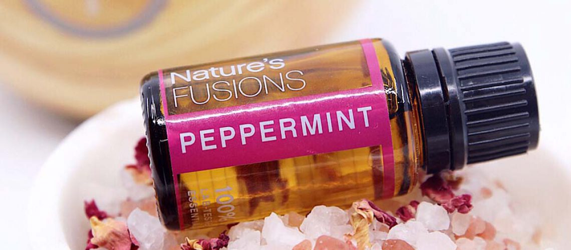 peppermint essential oil bottle on salt crystals and dried flowers